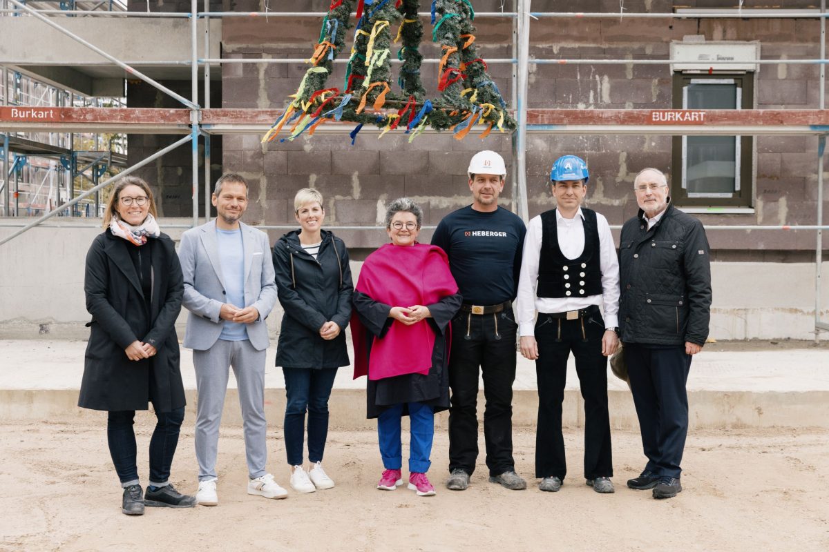 Sieben Personen stehen vor einem Gebäude bem Richtfest in Stutensee.