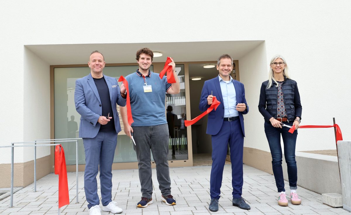 Symbolischer Banddurchschnitt bei der Fertigstellung der Woerishofferstraße. Vier Personen halten die durchgeschnittenen roten Bandstreifen in der Hand. Darunter sind Stefan Stortz, der Geschäftsführer der Volkswohnung und Daniel Fluhrer, baubürgermeister der Stadt Karlsruhe.
