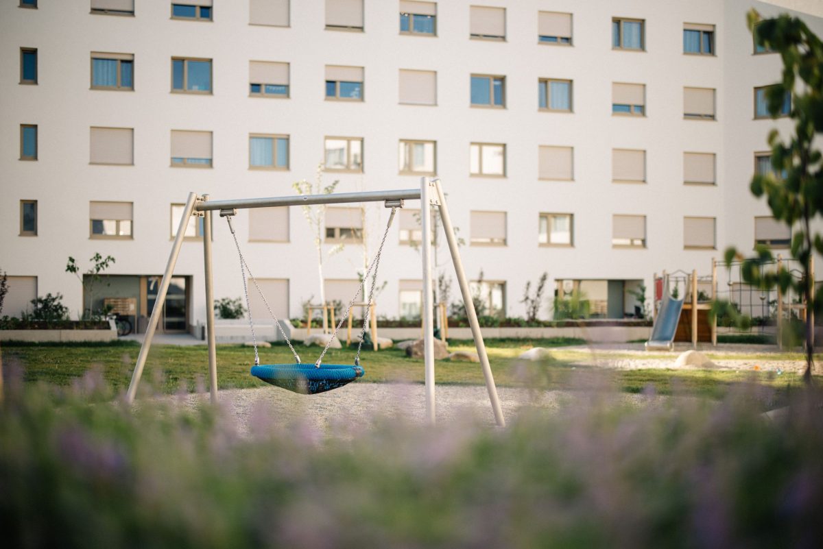 Ein Spielplatz in der Woerishofferstraße, eine Nestschaukel steht im Vordergrund.