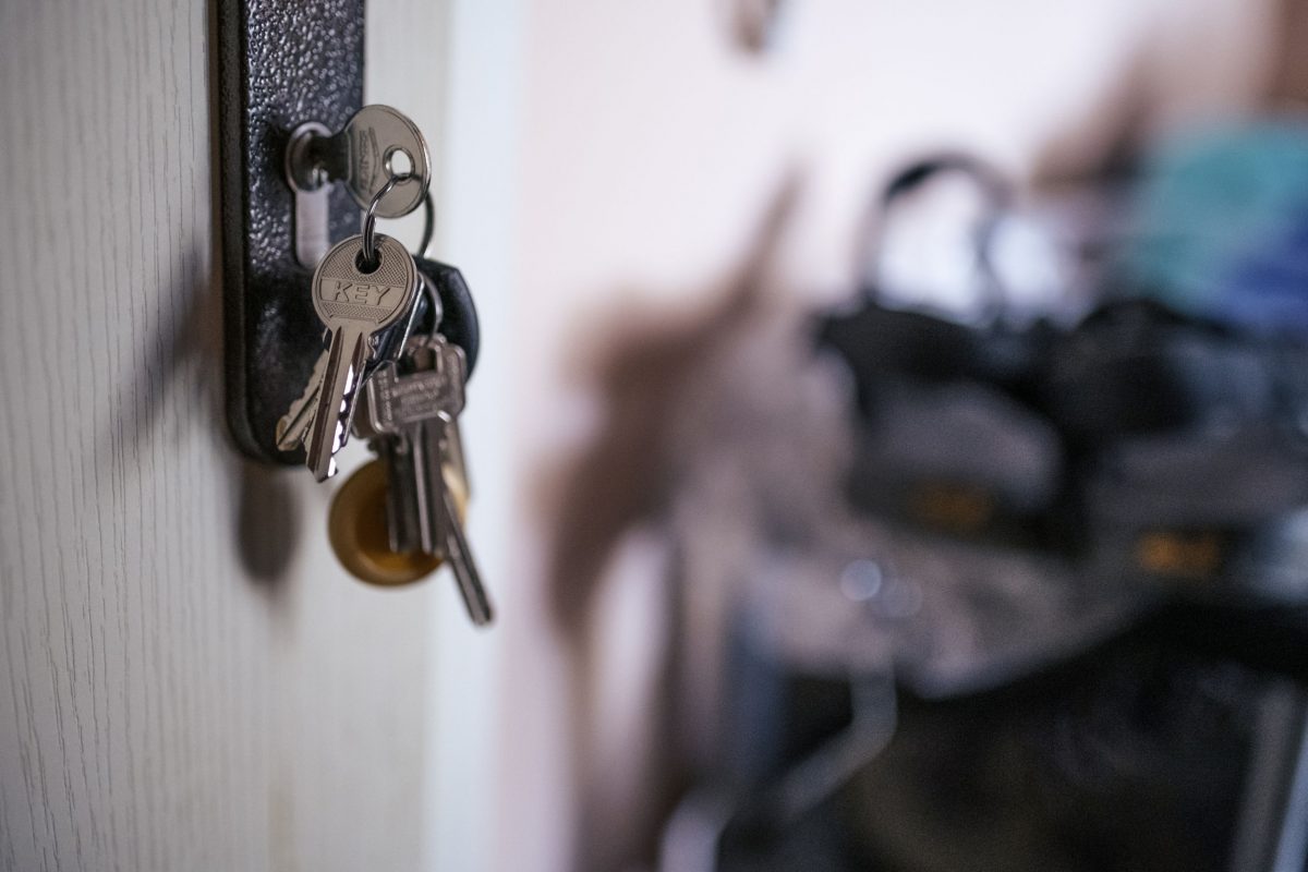 Ein Schlüssel steckt im Schloss einer Wohnungstür.