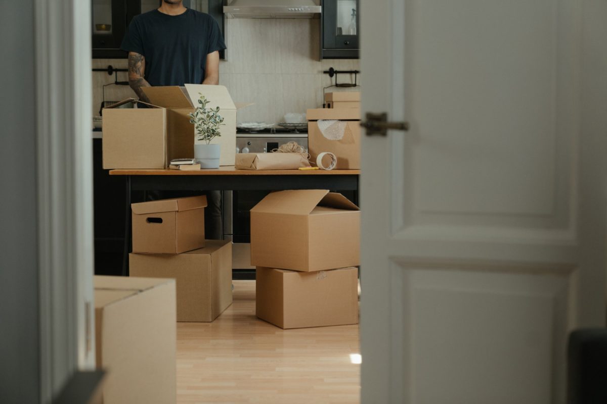 Blick in ein Zimmer, in dem für einen Umzug viele Kartons gestapelt sind.