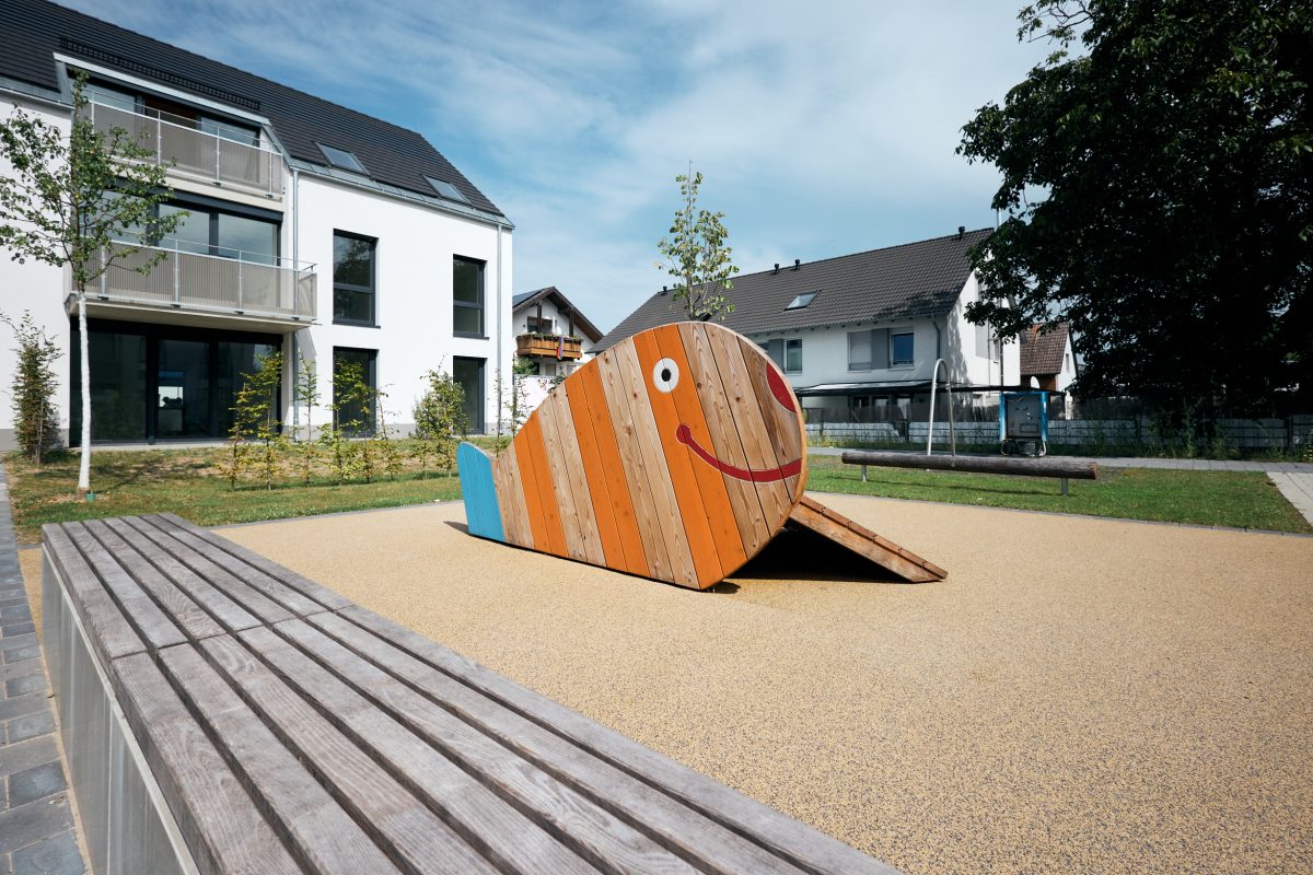 Ein Spielgerät auf einem Spielplatz, dass wie ein Wal aussieht, im Hintergrund stehen die Häuser der Wachausstraße in Karlsruhe-Durlach