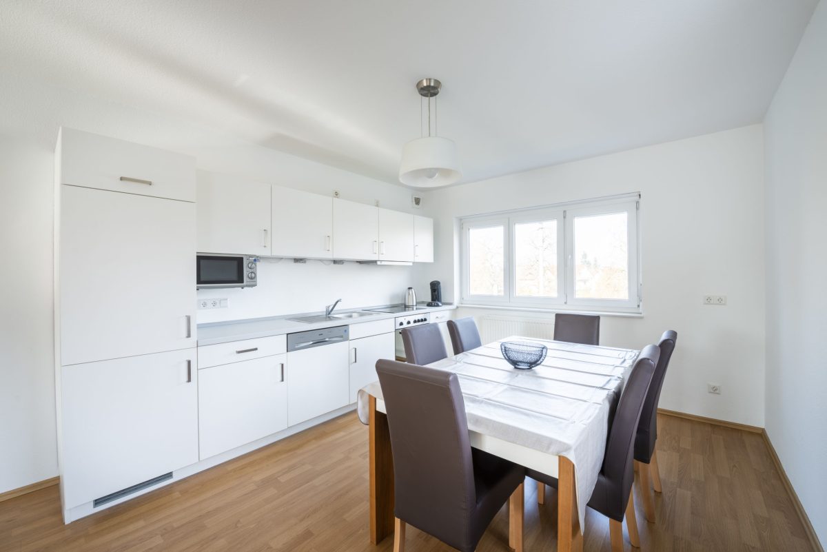 Die Küche der Gästewohnung im Rintheimer Feld. Es gibt einen Esstisch und sechs Sitzplätze.