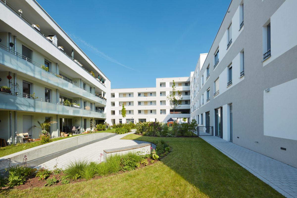 Rasenfläche und Blumenbeete gibt es zwischen den Gebäuden im Quartier am Albgrün.