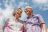 Ein älteres Ehepaar lacht zufrieden vor einem blauen Himmel mit Schleierwolken.