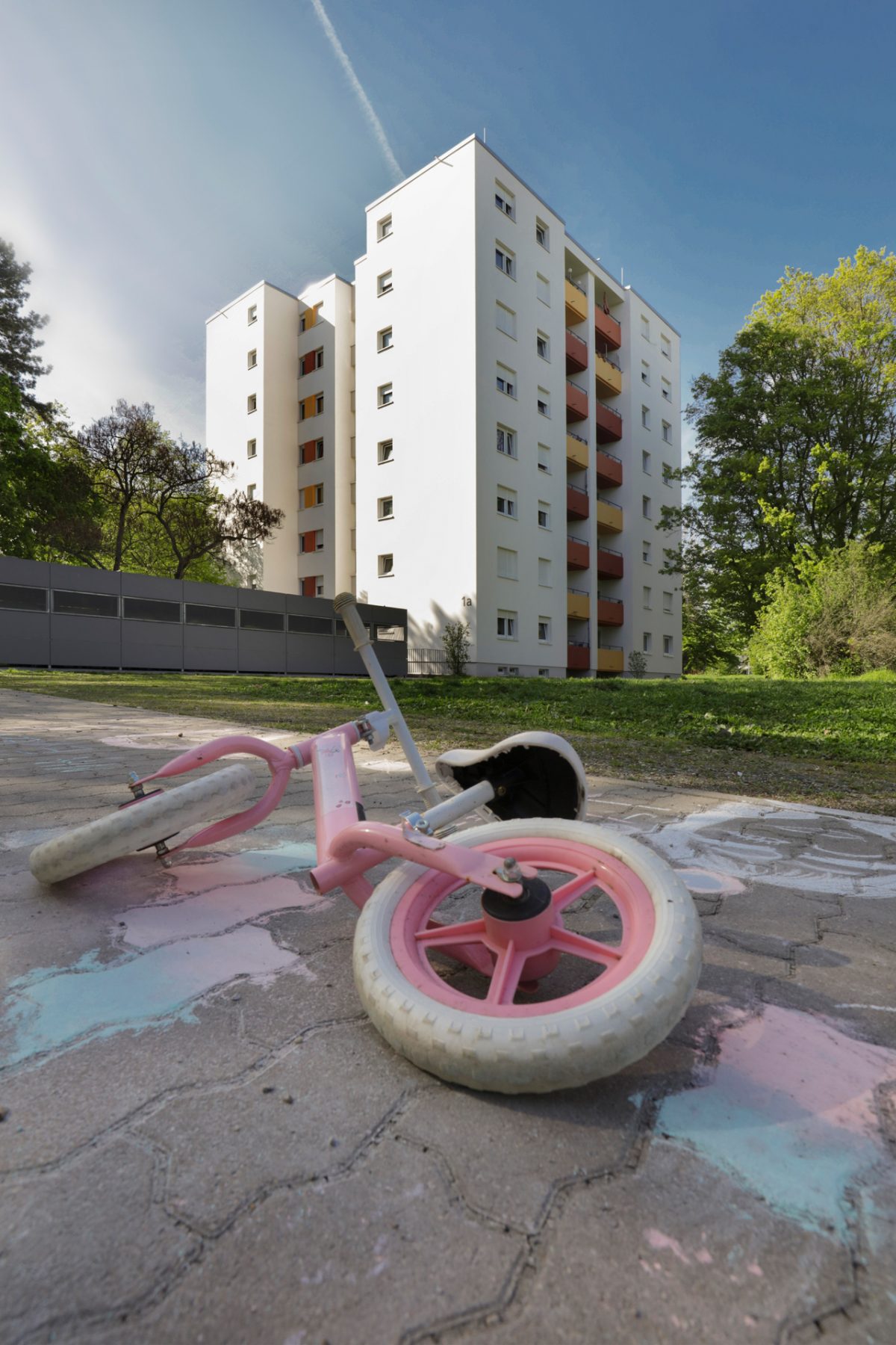 Außenansicht einer Wohnbebauung in der Nordweststadt, im Vordergrund liegt ein Kinderfahrrad.
