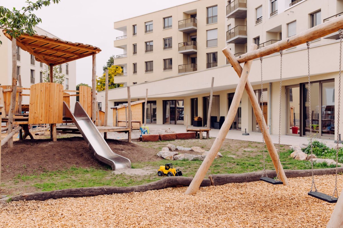 Hof der Kita im August-Klingler-Areal, es sind verschiedene Spielgeräte wie z.B. eine Rutsche zu sehen.