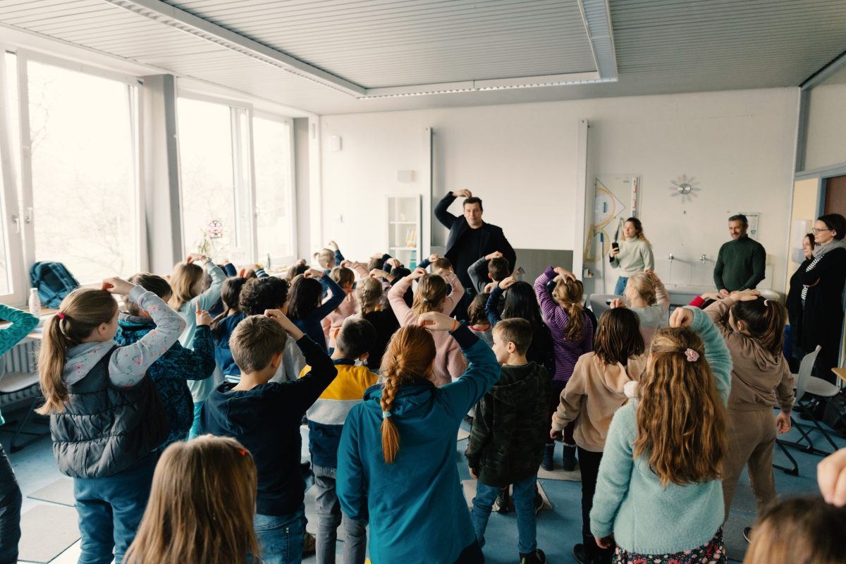 Kinder machen Übungen mit dem Autor bei der Autorenlesung an der Werner-Siemens-Schule.
