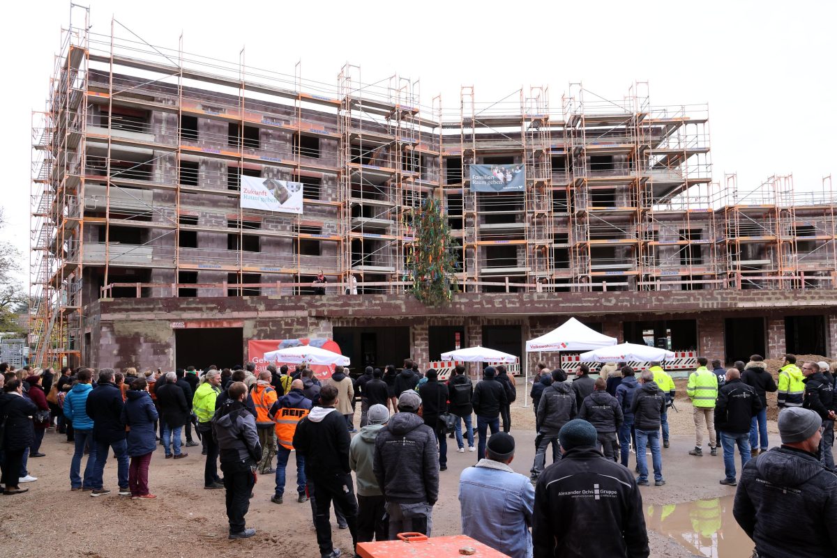 Richtfest des August-Klingler-Areals. Viele Personen stehen draußen vor dem Gebäude. Das Gebäude ist von einem Gerüst umbaut.