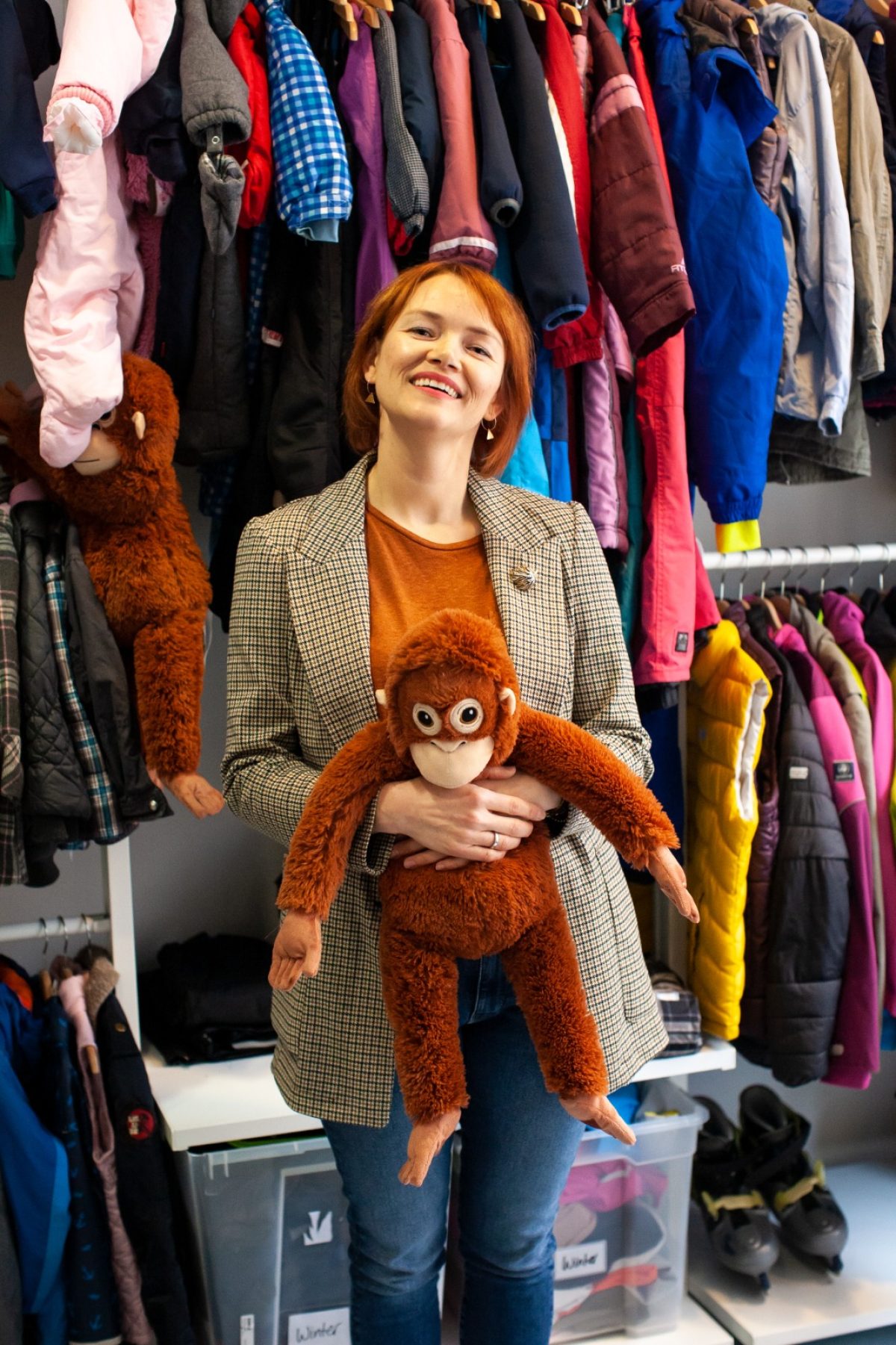 Die Inhaberin des Kleiderladen Nimms mit hält einen Affen aus Plüsch in den Händen.