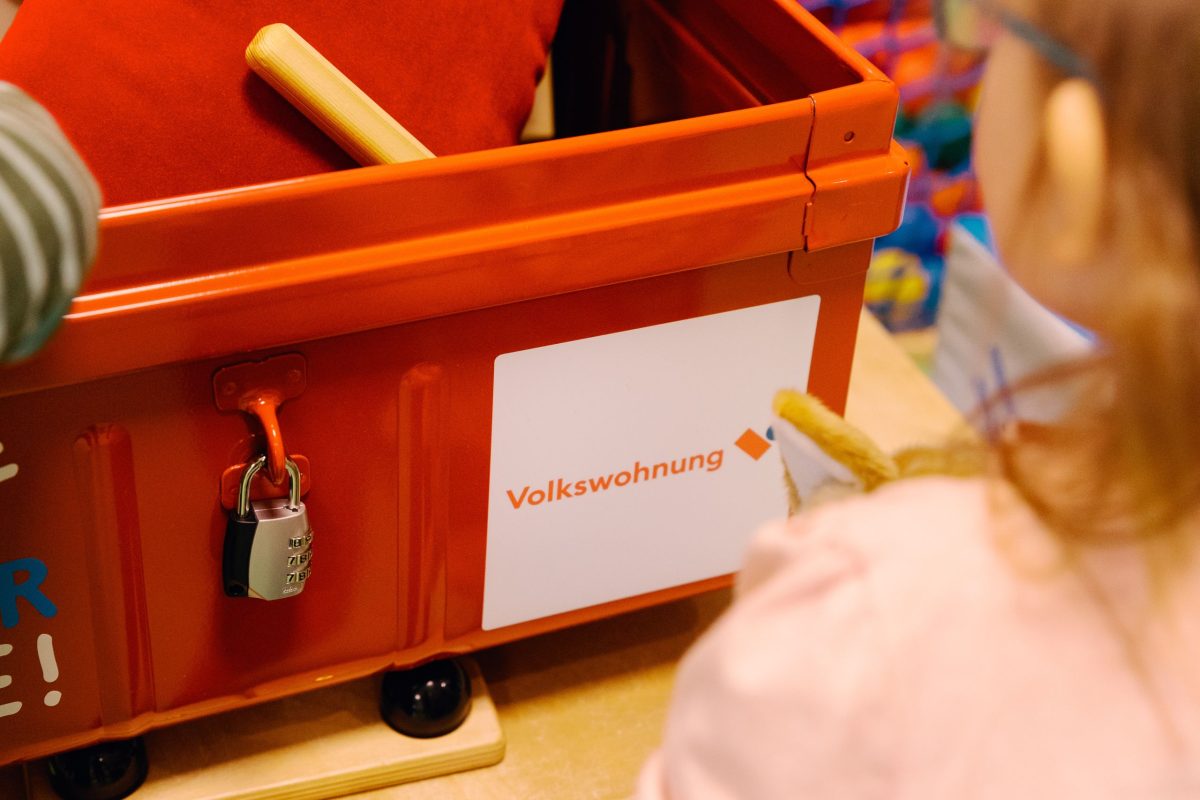 Ein Mädchen schaut sich den Inhalt der Kiste an.