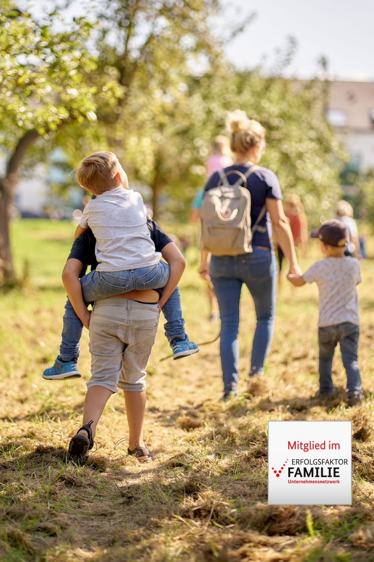 Eine Familie läuft durchs Grüne. Im Bild das Logo 