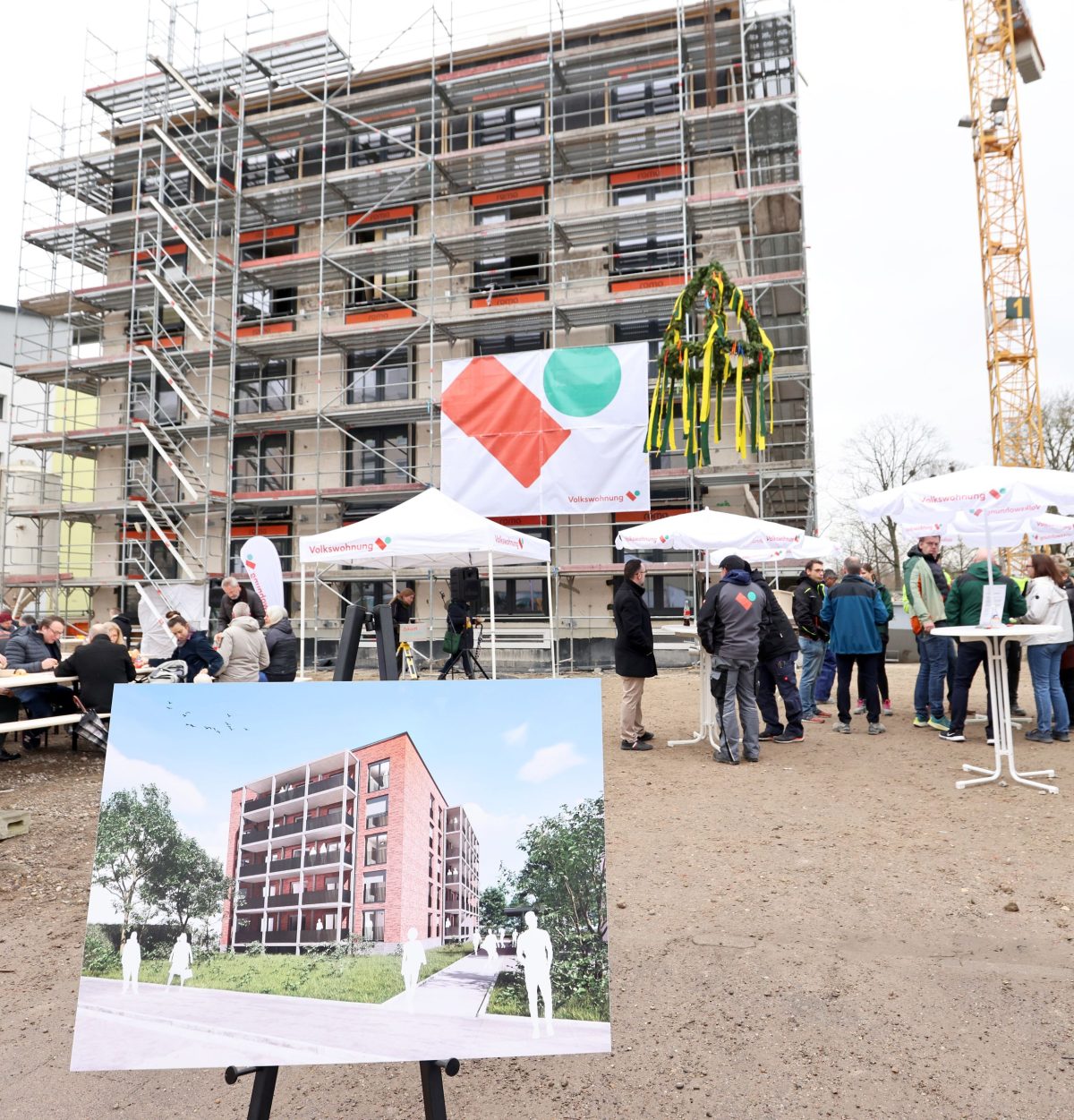 Im Vordergrund sieht man die Visualisierung, wie das Gebäude im Hintergrund später aussehen soll.