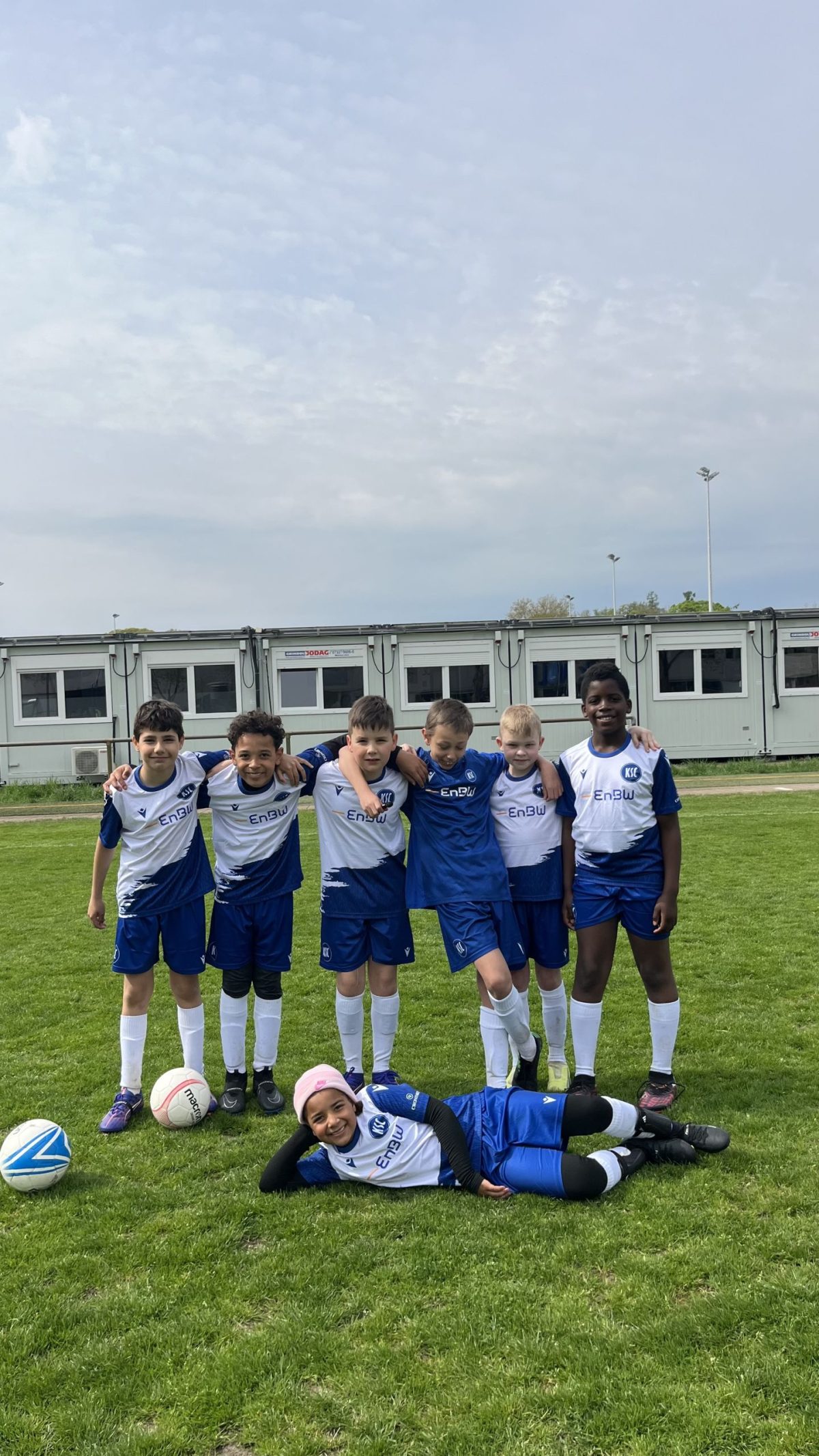Gruppenbild mit sieben Kindern im Trikot auf dem Rasen im BBBank Wildpark.