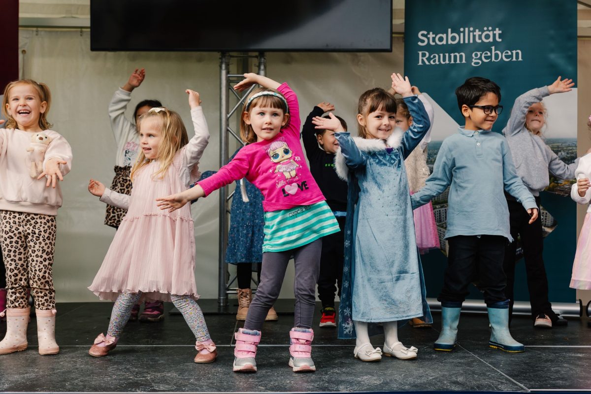 Mehrere Kindergartenkinder beim Auftritt auf einer Bühne bei der Fertigstellungsfeier des August-Klinger-Areals.
