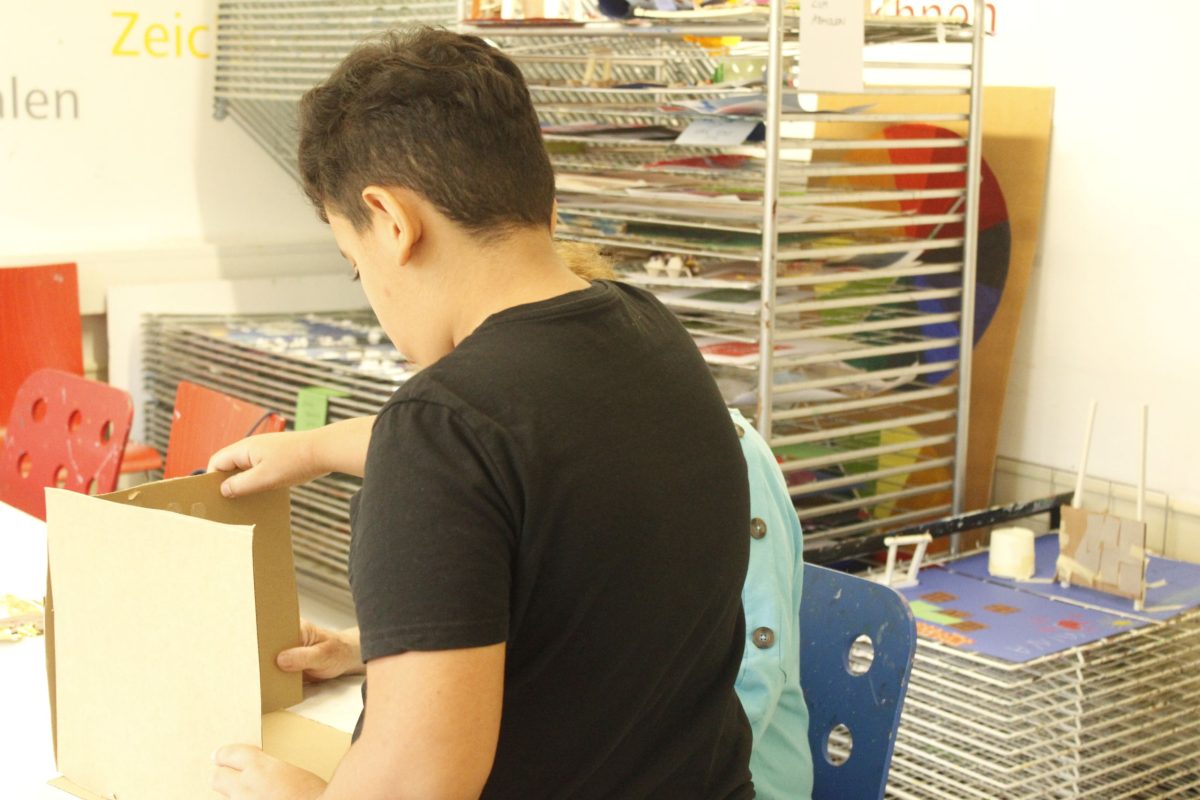 Ein Junge baut aus Pappe seinen eigenen Traum-Raum.