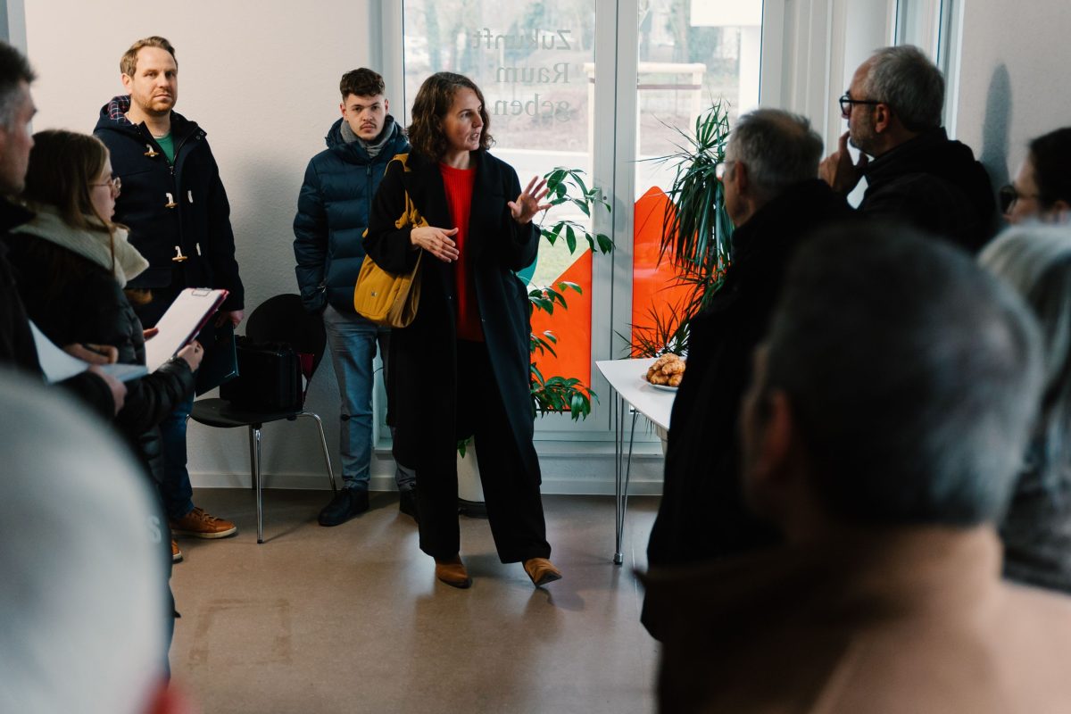 10 Personen stehen im Servicebüro des August-Klinger-Arials. Anja Kulik erläutert Informationen zum Quartier.