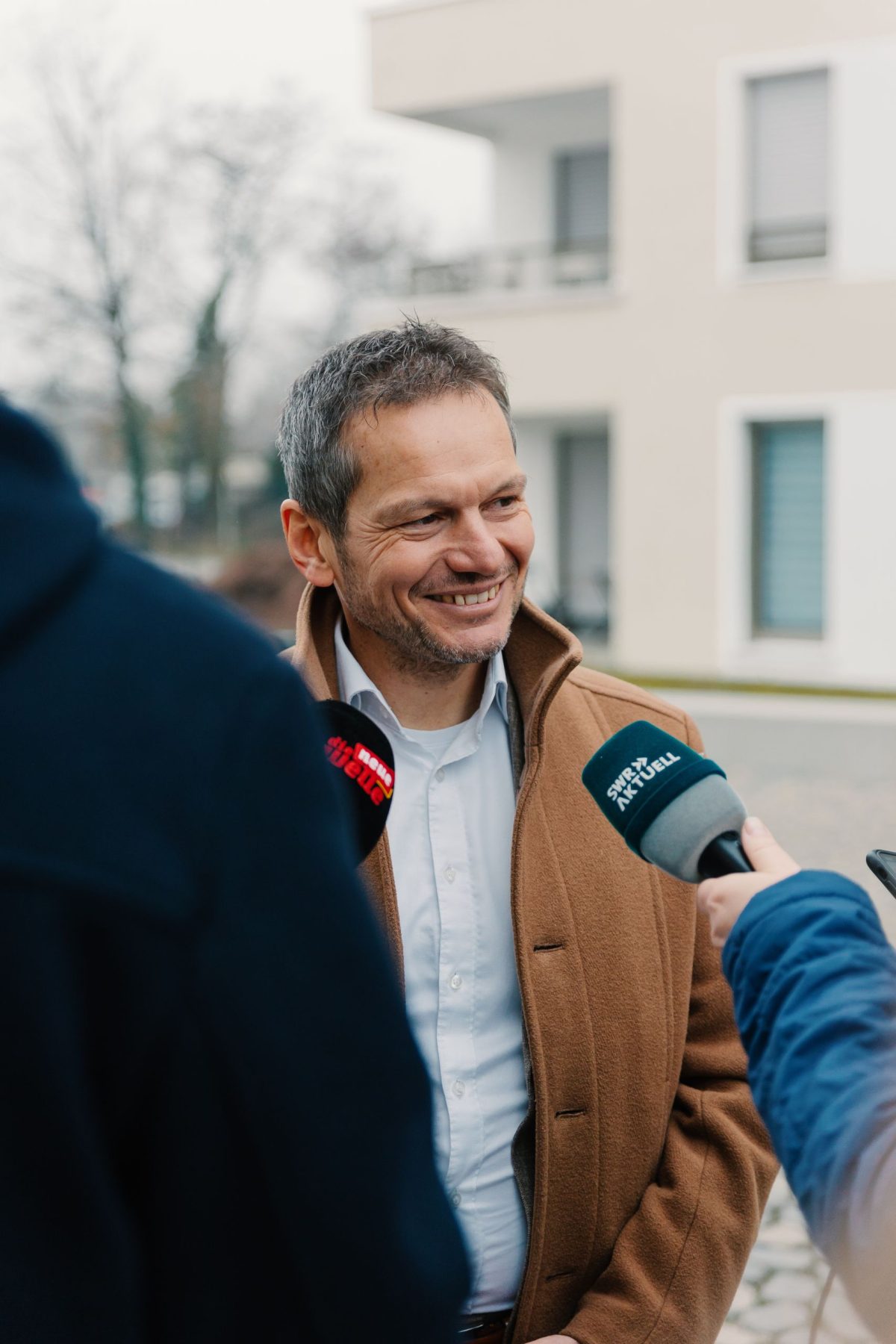 Stefan Storz, Geschäftsführer der Volkswohnung wird interviewt. Ihm werden zwei Mikrophone entgegengehalten.