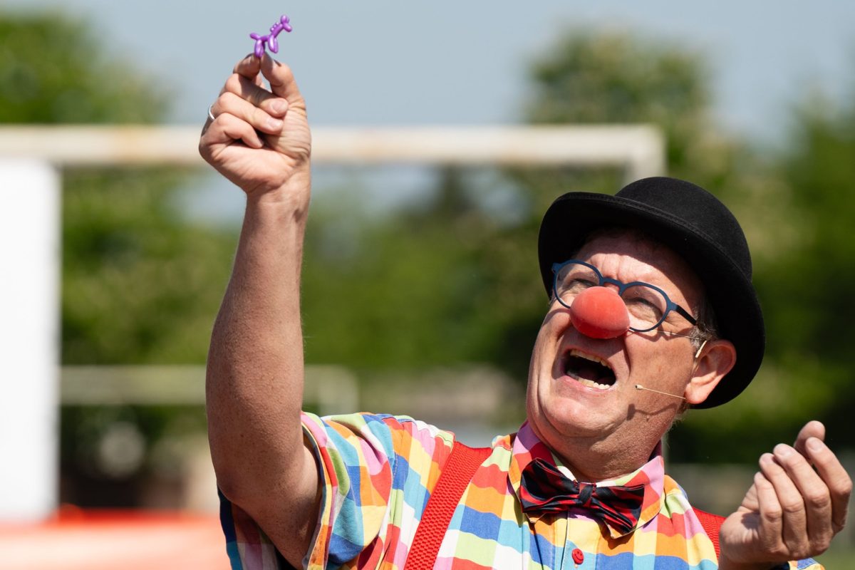 Clown Benji hält eine Blume hoch