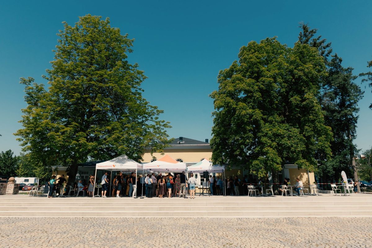 Gebäude des ehemaligen Vereinsheims im August-Klingler-Areal bei der Fertigstellungsfeier. Rechts und Links stehen zwei große Bäume, in der Mitte sind Pavillons aufgebaut.