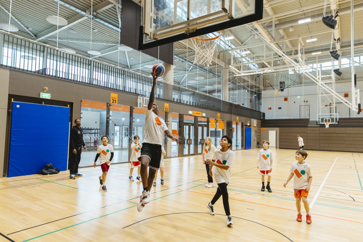 Mehrere Kinder spielen Basketball.