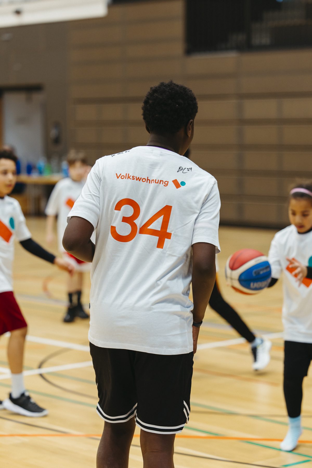Mehrere Kinder spielen Basketball.