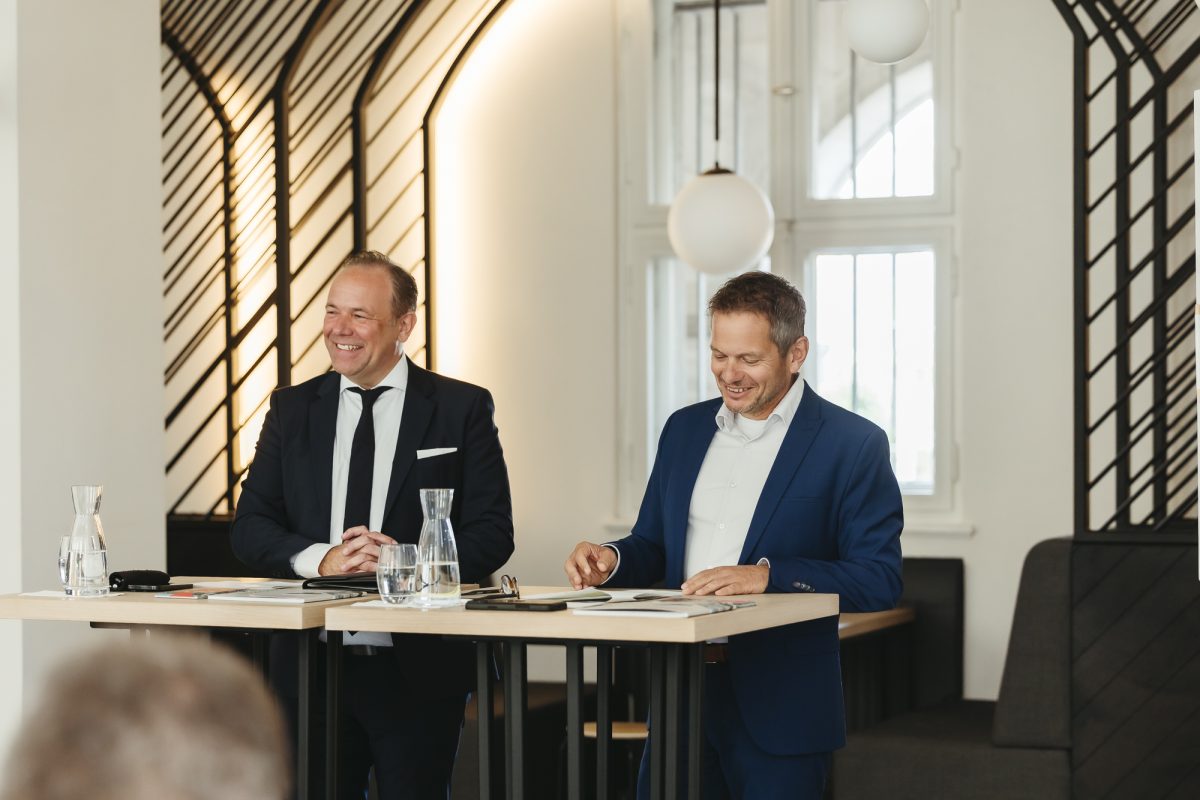 Daniel Fluhrer und Stefan Storz stehen hinter zwei Stehtischen und halten die Jahrespressekonferenz ab.